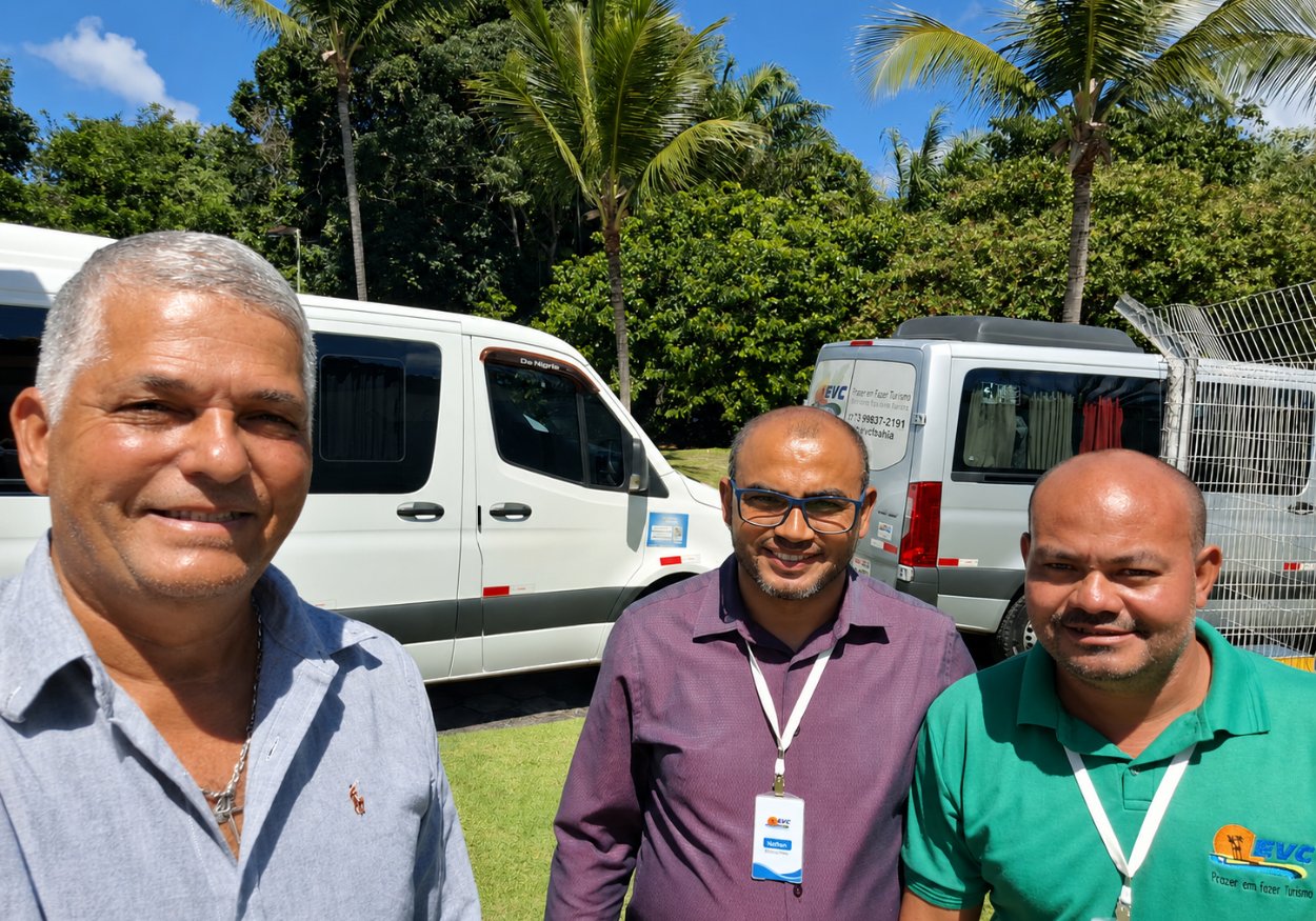 Edson e dois motoristas da EVC Turismo com crachá, diante das vans